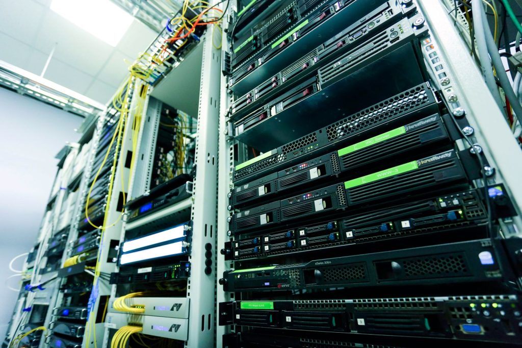 Redata: nova lei cria incentivos para data centers e exige investimentos no Brasil Rack de servidores de alta tecnologia em um data center, com cabos de rede e componentes de hardware.