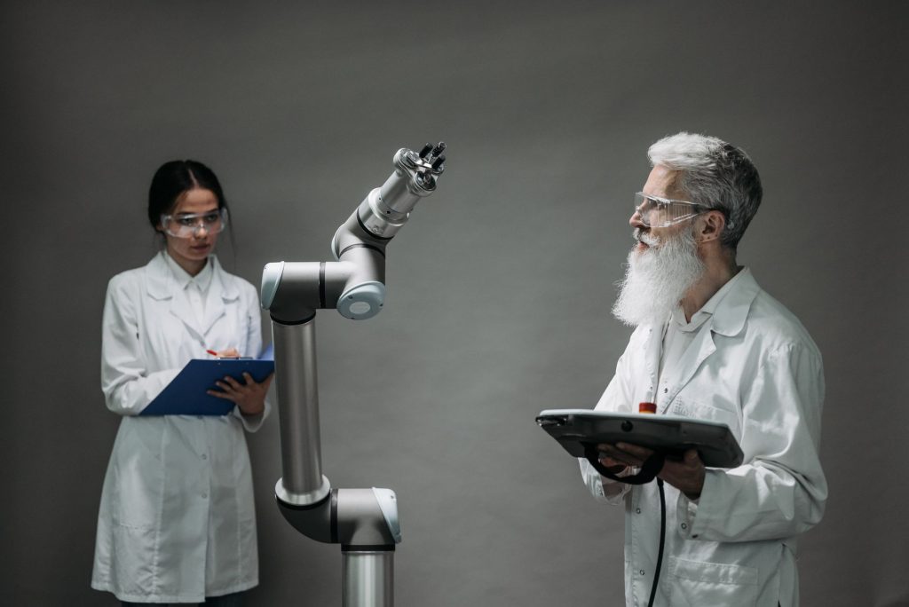 CNPq reforça chamada científica na América Latina com R$ 160 milhões para inovação e IA Dois cientistas trabalham com um braço robótico em um laboratório de alta tecnologia.